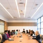 Equipe multicultural reunida em uma sala, colaborando e discutindo estratégias em uma reunião.