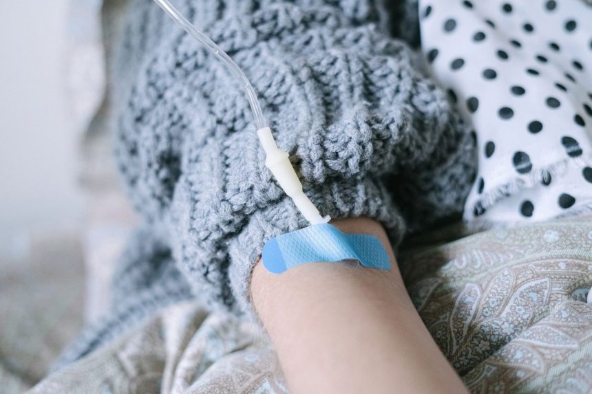 Close-up de um paciente recebendo terapia intravenosa durante tratamento contra o câncer em uma unidade de saúde.