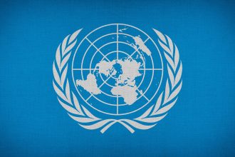 Detalhe de uma bandeira da Organização das Nações Unidas, símbolo da atuação multilateral internacional.